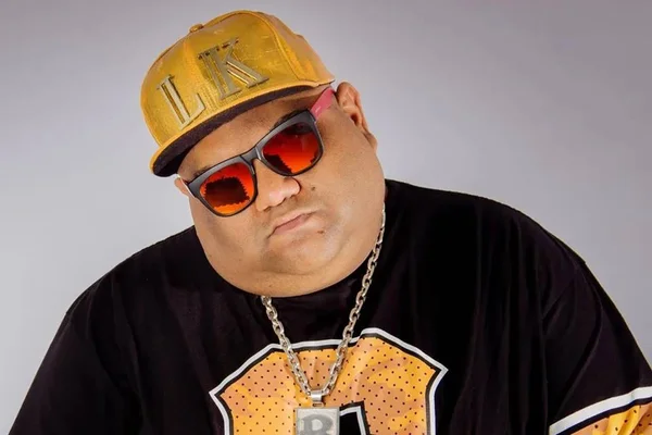 Foto colorida de DJ Baphafinha usando boné, cordão e blusa preta - Metrópoles