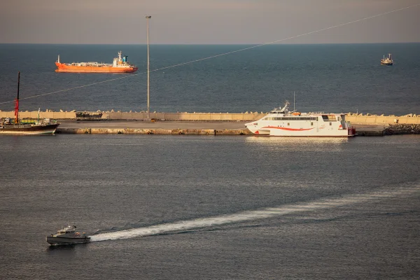 Uma lancha da polícia patrulha o porto enquanto petroleiros e embarcações de alta velocidade permanecem ancorados na área de ancoragem de Mascate, perto do Estreito de Ormuz - Metrópoles