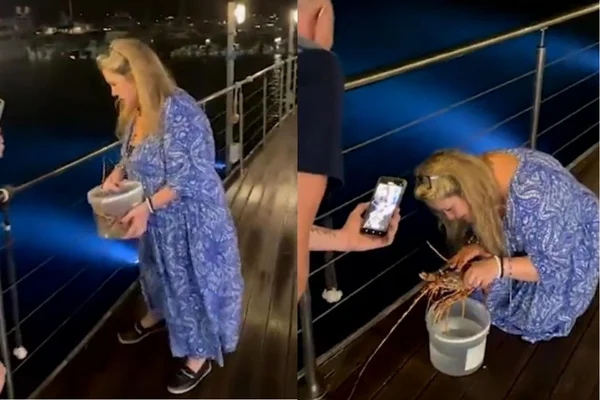 Foto colorida de uma mulher segurando uma lagosta - Metrópoles