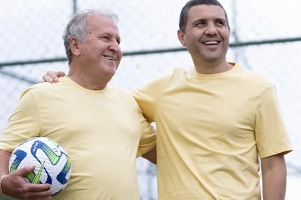 Zico posa ao lado do filho, Bruno Coimbra, ambos de blusa amarela - Metrópoles