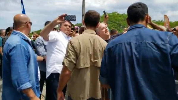 Presidente Jair Bolsonaro faz selfie com apoiador, em São Francisco do Sul (SC)