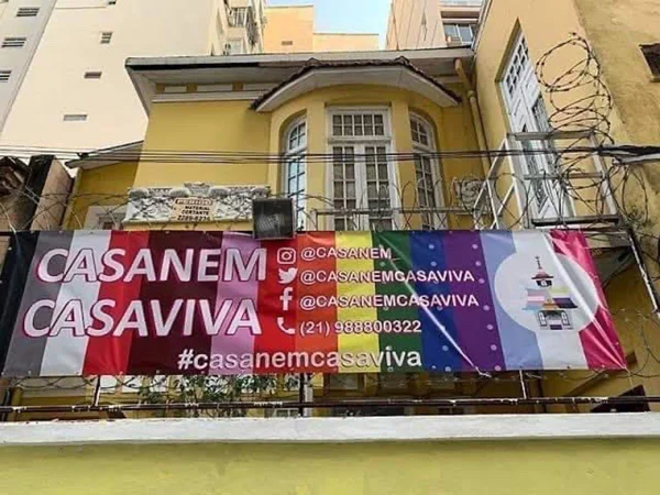 fachada de uma casa amarela com uma faixa colorida da CasaNem