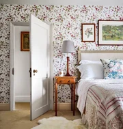Já neste outro quarto, o que chama mais a atenção é o papel de parede, em perfeita harmonia com a colcha vintage