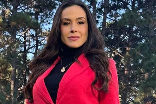 Nadja Haddad posa, séria, com um look preto e vermelho - Metrópoles