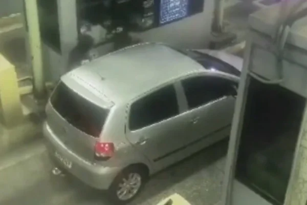 Imagem colorida de suspeitos roubando carro em pedágio. Metrópoles
