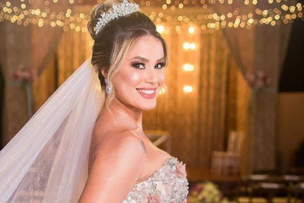mulher posa sorrindo vestida de noiva - metrópoles