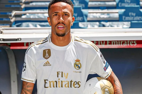 Éder Militão posa com uma bola no braço e de uniforme do Real Madrid - Metrópoles
