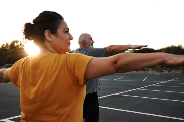 Um casal de meia-idade está praticando exercícios de ioga. Risco de morte 50 anos saudável meia idade exercícios físicos