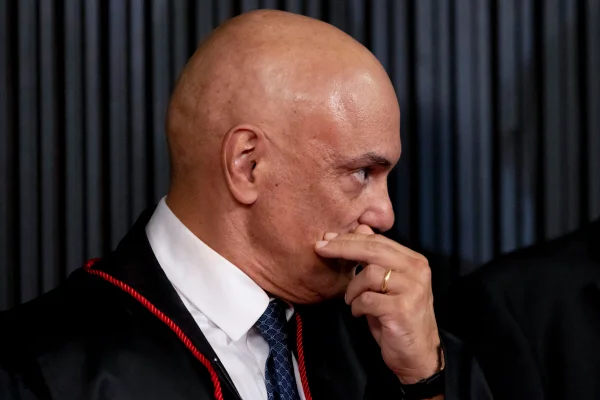 Imagem colorida de Alexandre de Moraes, presidente do TSE, com as mãos no rosto