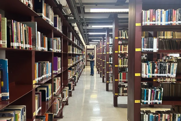 Imagem colorida de estantes de livros em biblioteca