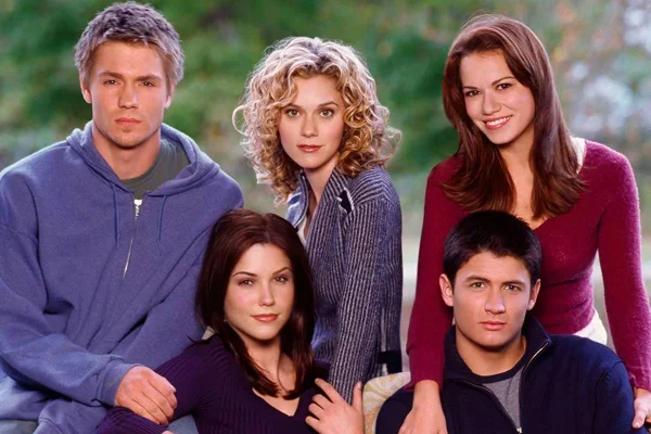 Imagem colorida da série One Tree Hill mostra jovens sentados lado a lado - Metrópoles