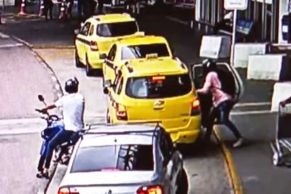 na foto vemos uma fila de taxis e uma pessoa entrando no ultimo taxi