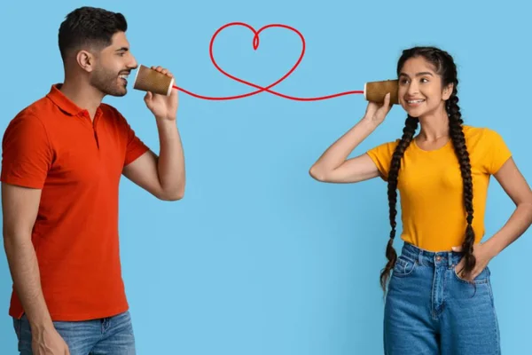 Casal com telefone sem fio fazendo coração