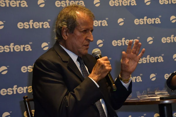 Imagem colorida de Valdemar Costa Neto em frente a painel do grupo Esfera