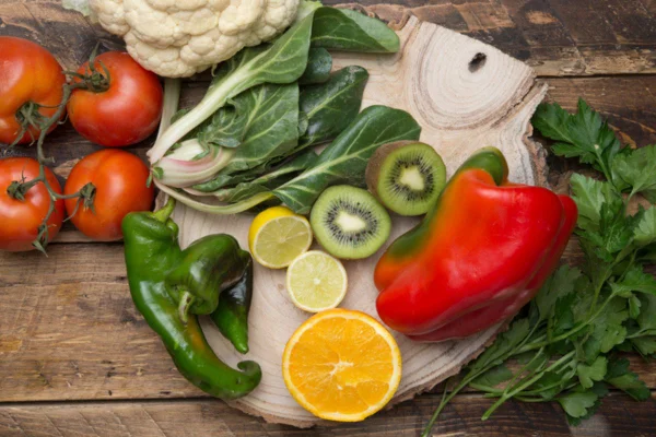 Imagem colorida de frutas em verduras sob tábua