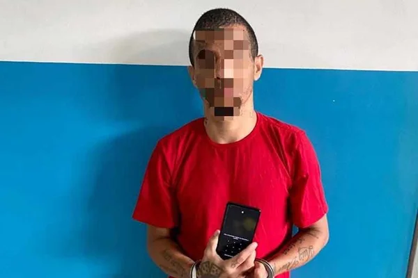 Foto colorida de detento com celular na prisão de Alagoas - Metrópoles