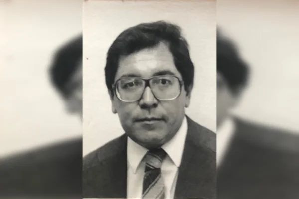 Homem de óculos, terno e gravata em imagem preto e branco