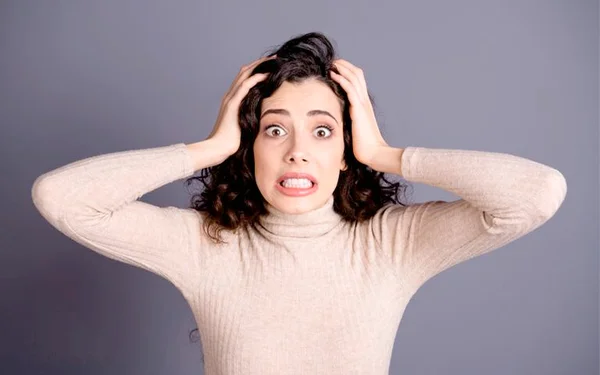 Mulher com cara de desespero e mão na cabeça