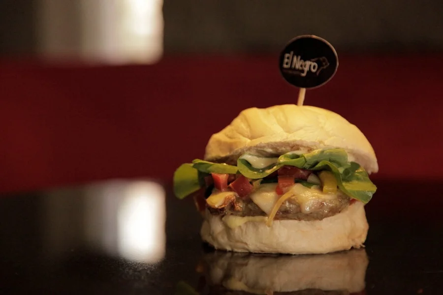 O Kalango Burguer tem hambúrguer de frango, queijo provolone, vinagrete, rúcula e maionese do cerrado O Kalango Burguer tem hambúrguer de frango, queijo provolone, vinagrete, rúcula e maionese do cerrado
