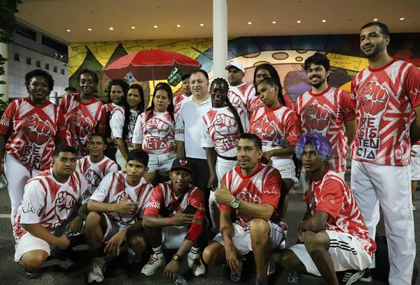 pessoas posam para foto juntas. elas vestem a camisa da escola de samba Salgueiro