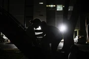 Crianças brincam em parquinho escuro e somente com a presença de responsáveis