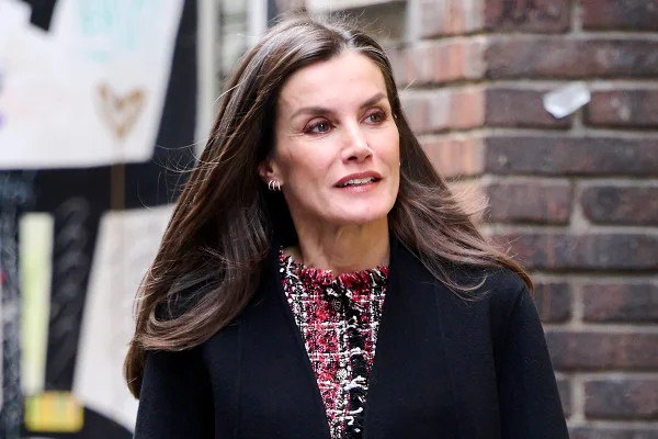 Foto de mulher com o cabelo castanho, usando uma blusa de tweed e um casaco preto - Metrópoles