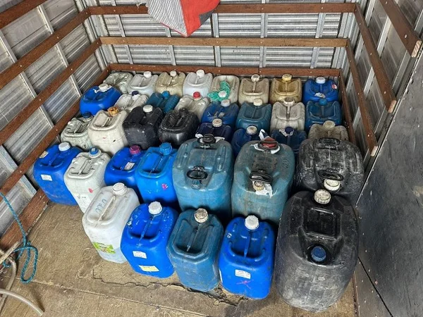 Imagem colorida mostra diversos galões, a maioria na cor azul e alguns na cor branca, que foram apreendidos pela Polícia Civil em uma operação que descobriu uma fábrica de gasolina falsa - Metrópoles