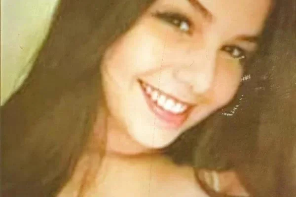 Imagem colorida de Débora Almeida Monteiro. Ela tem cabelos longos, está de batom e sorri para foto - Metrópoles