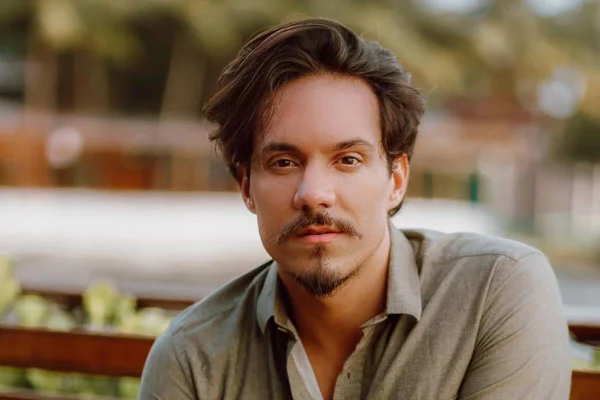 Foto colorida de Eliezer. Ele usa uma camisa polo verde, tem pele clara, cabelo grande e preto e um bigode preto - Metrópoles