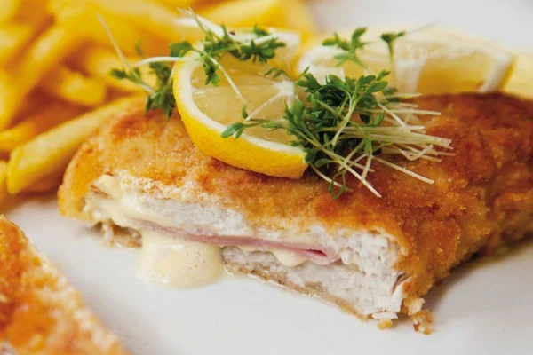 frango recheado com batata frita em prato branco