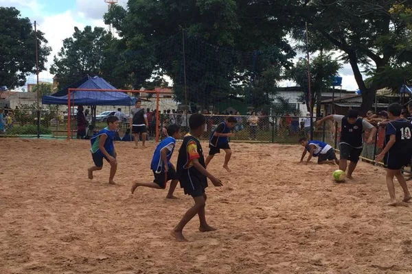 meninos em quadra de areia jogando volei