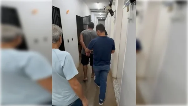 Homem algemado sendo conduzido para uma cela - Metrópoles