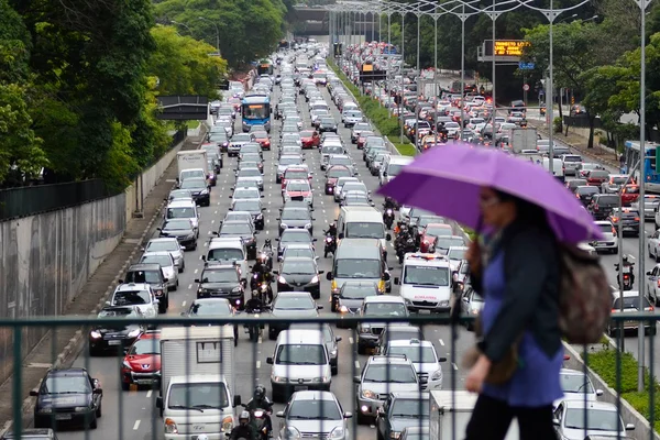 Mulher andando por São Paulo com trânsito de carros ao fundo - Metrópoles