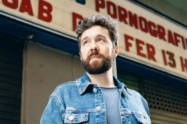 Foto colorida de Teo Pasquini olhando para o alto, com barba - Metrópoles