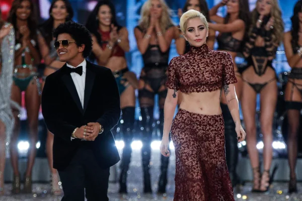 Imagem colorida de Bruno Mars e Lady Gaga juntos em um desfile da Victorias Secret