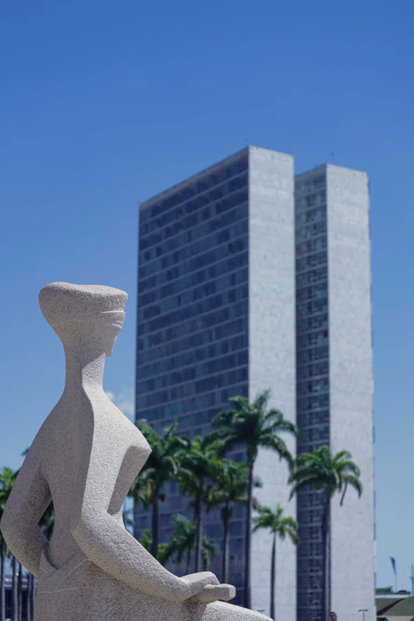 Imagem colorida da estátua do STF com Congresso ao fundo - Metrópoles