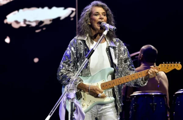 Cantora Simone - a do "Então é Natal" , de cabelo branco com guitarra na mão em palco - Metrópoles