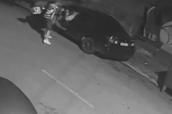 Imagem preto e branco mostra homem atirando contra motorista dentro de carro - Metrópoles