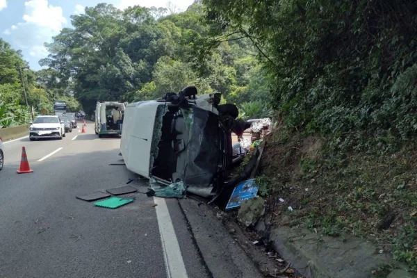 Imagem colorida mostra van tombada após acidente da Anchieta - Metrópoles