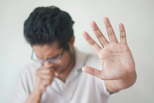 Foto colorida de homem tocindo