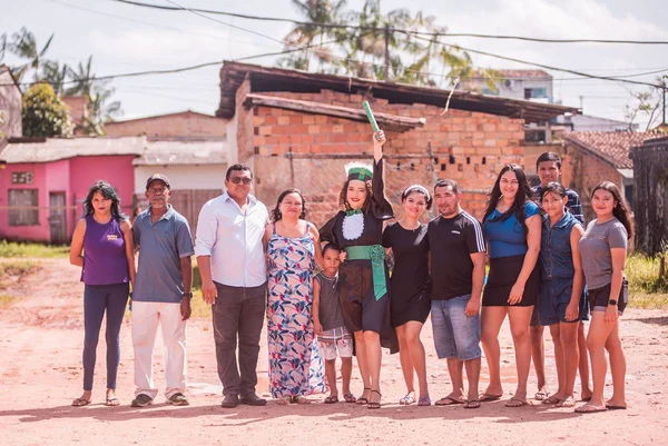 Foto colorida de estudante e sua família