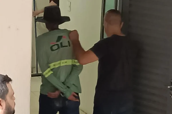 Imagem colorida de um homem conduzindo outro, ambos de costas para a câmera