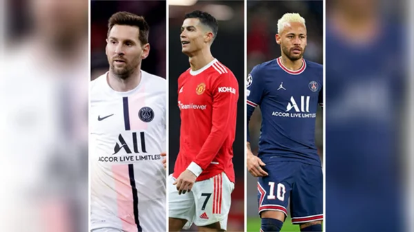 Messi, Cristiano Ronaldo e Neymar em atuações da temporada 2021/2022. Da esquerda para direita, Messi veste camisa branca do PSG durante partida do Campeonato Francês. Ao centro, Cristiano Ronaldo com camisa do Manchester United, de cor vermelha, em partida do Campeonato Inglês. No canto direito da imagem, Neymar veste o uniforme azul do PSG em duelo do Campeonato Francês.
