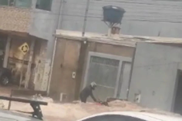 Foto colorida de homem segurando motocicleta arrastada