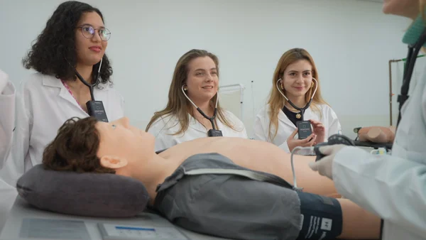 Fotografia colorida mostrando alunos de medicina em treinamento com boneco-Metrópoles