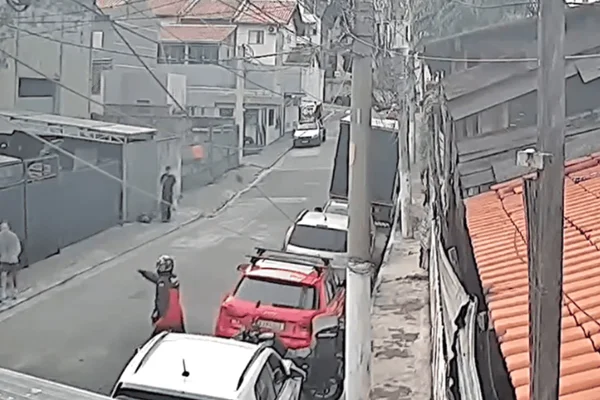 Imagem colorida de motociclista armado abordando homem na rua - Metrópoles