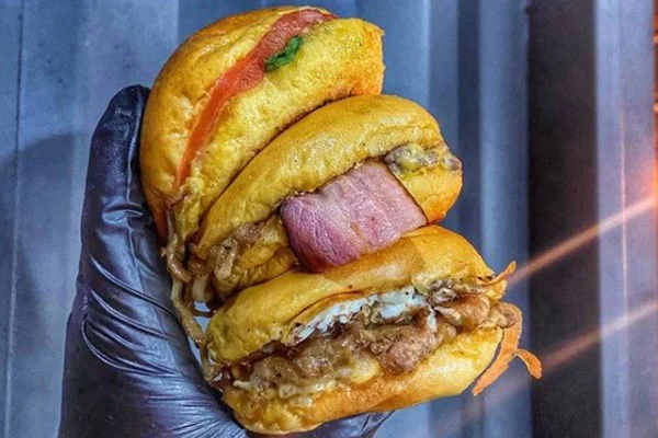 Hamburgueres empilhados na mão de uma pessoa