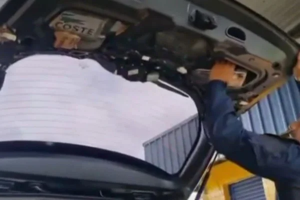 Imagem colorida mostra policiais tirando drogas de forro de carro no interior de São Paulo - Metrópoles