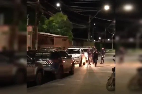 Carros estacionados em frente a casas em rua à noite