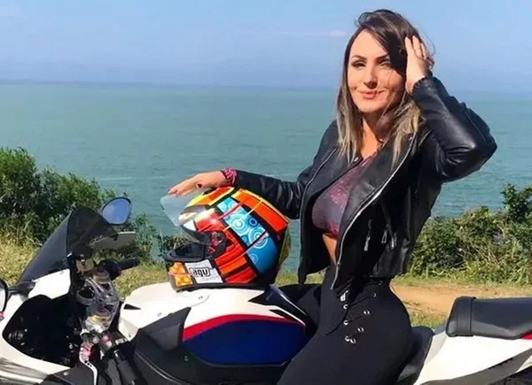 mulher loira posa para foto em cima de uma moto